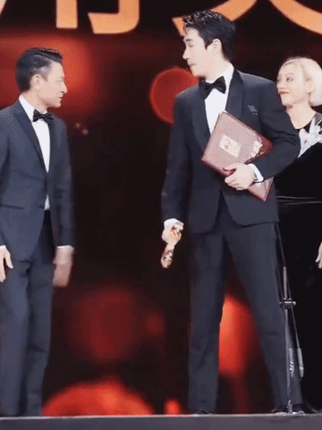 宁静在刘德华面前好乖啊，刘德华手一伸，宁静就听话的赶紧把手递给华哥牵着，题词卡还