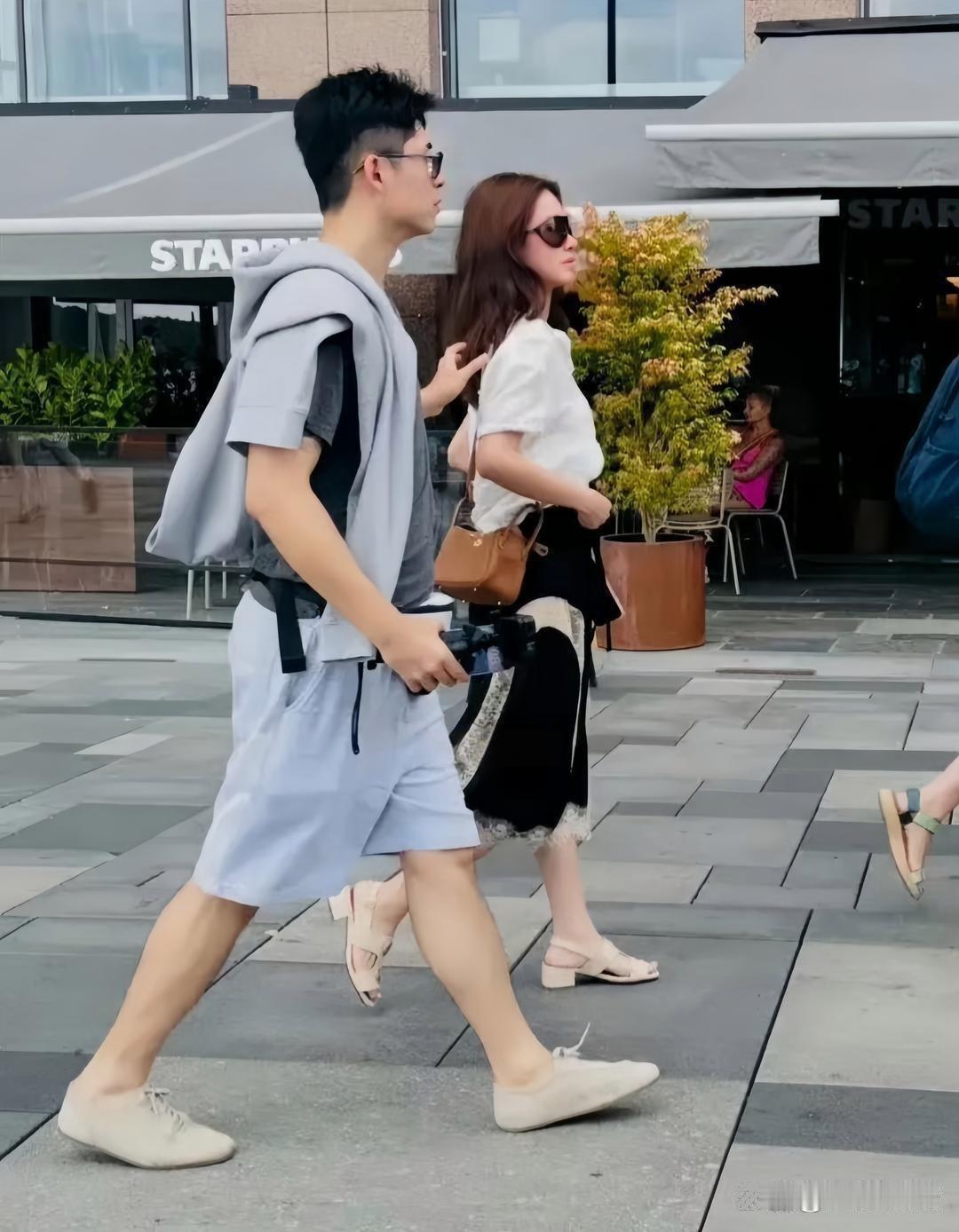 杨采钰和老公张向荣现身挪威看世界杯，夫妇俩在街头打卡拍照，杨采钰打扮时尚有型，戴