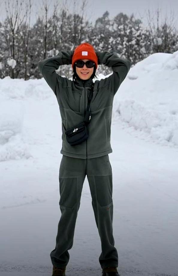 60岁刘嘉玲，雪地里一件薄衫。她站在北海道齐膝的雪中，一身暗绿，头顶一抹