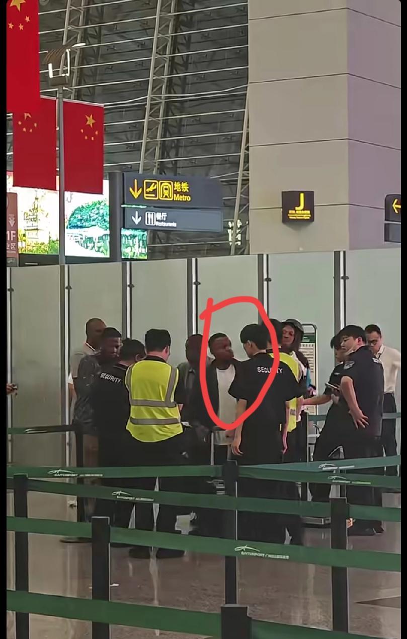 广州白云机场，黑人行李超重。机场工作人员按规定不让过，黑人大声呵斥，直接推开工作