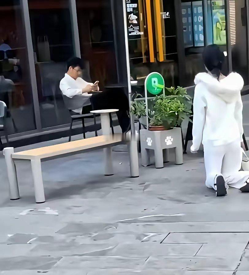 上海街头，一年轻貌美女子跪地哭泣男子坐椅子上低头玩手机发生了什么事？