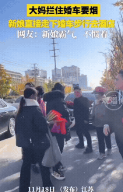 江苏一新娘坐婚车去酒店，结果，途中被一群大妈拦住，索要烟，给少了还不行！新娘一看