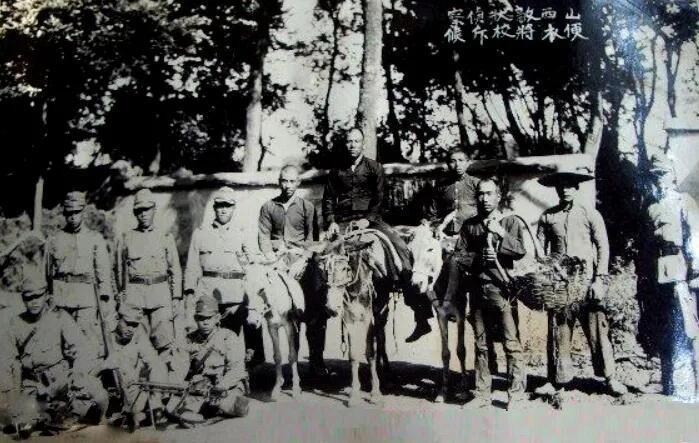 这张拍摄于1937年的日军合影，处处透着阴森与狡诈。画面里，队伍中央有“中国百姓