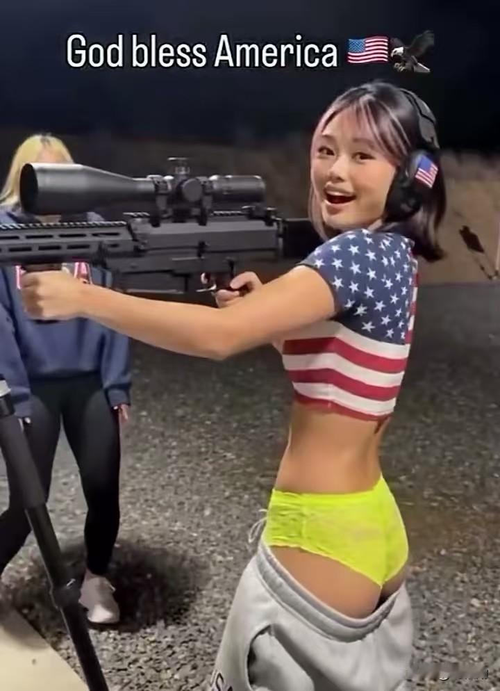 华人女孩身处美国射击场，满身美式符号加持。星条旗上衣、国旗标识耳机，架起威力巨大