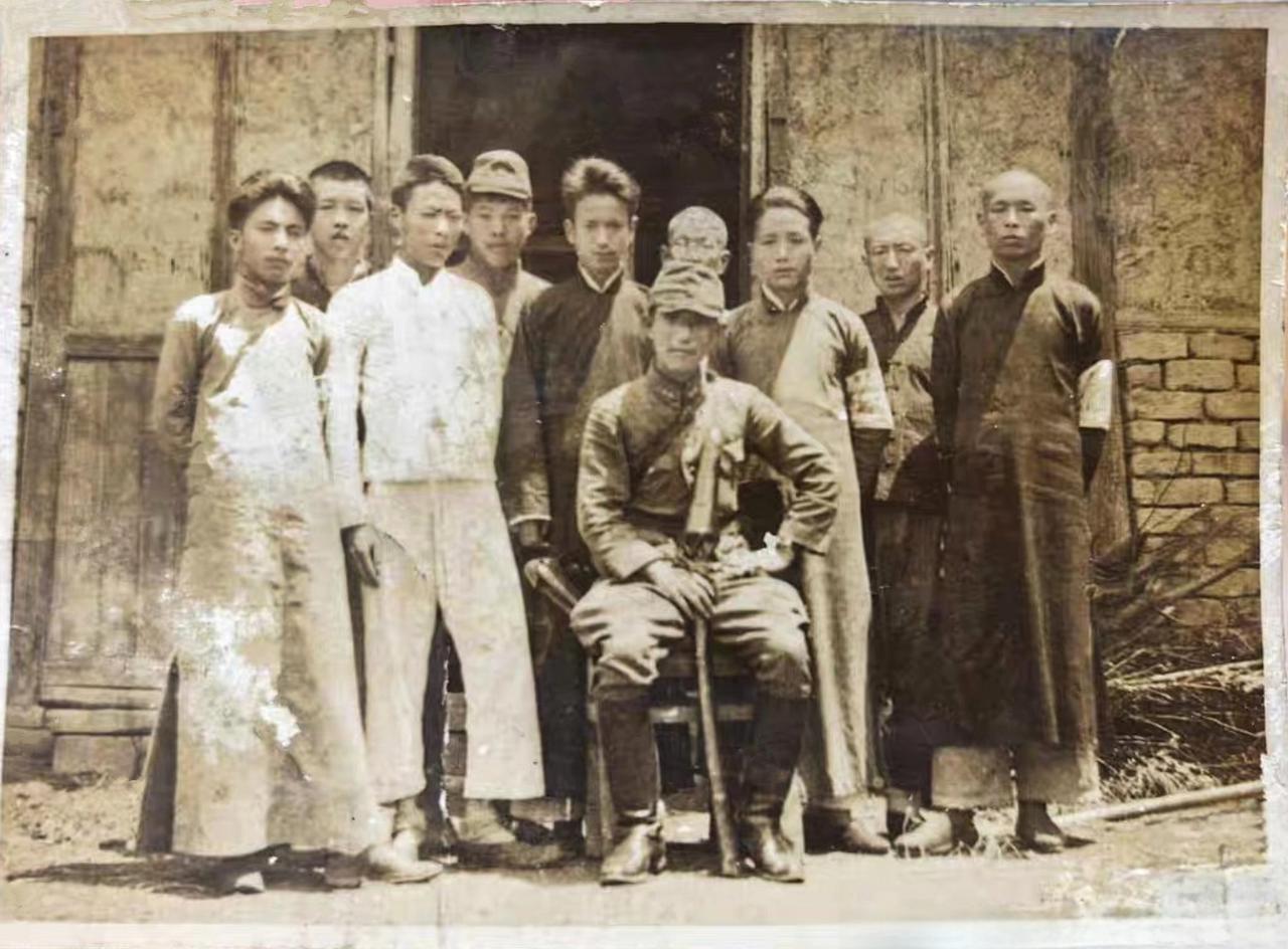 这是日军和9个中国人的合影照片。从照片上看，这个日军的级别还不低，他搬来椅子坐在