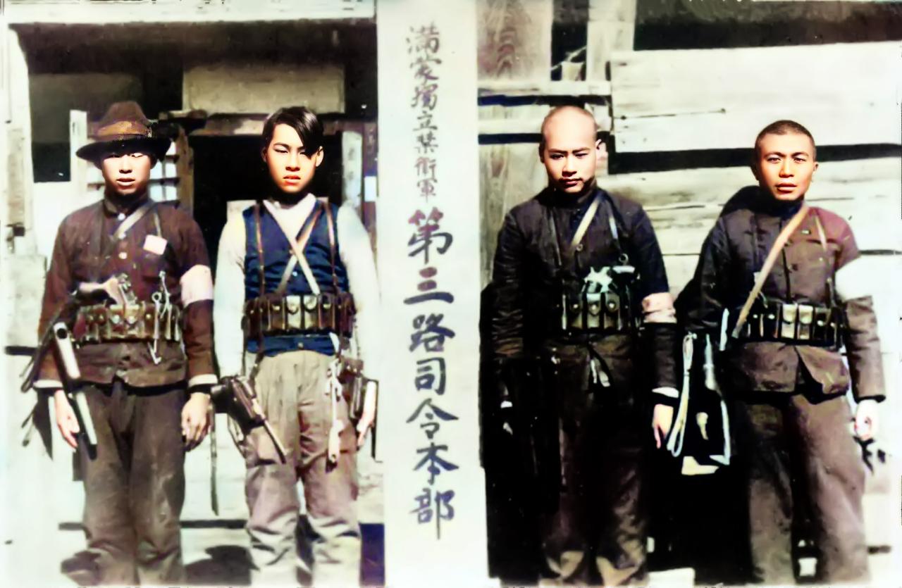 不幸被俘的四名抗日义勇军的头领，为了羞辱，日本人在拍照时依然把武器挂在他们身上。