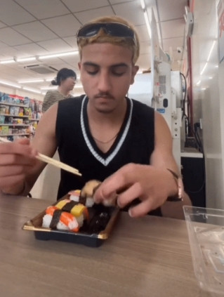 笑不活了！一外国小伙在便利店买寿司。趁没人注意，闪电般伸手抓起寿司塞进嘴。下一秒