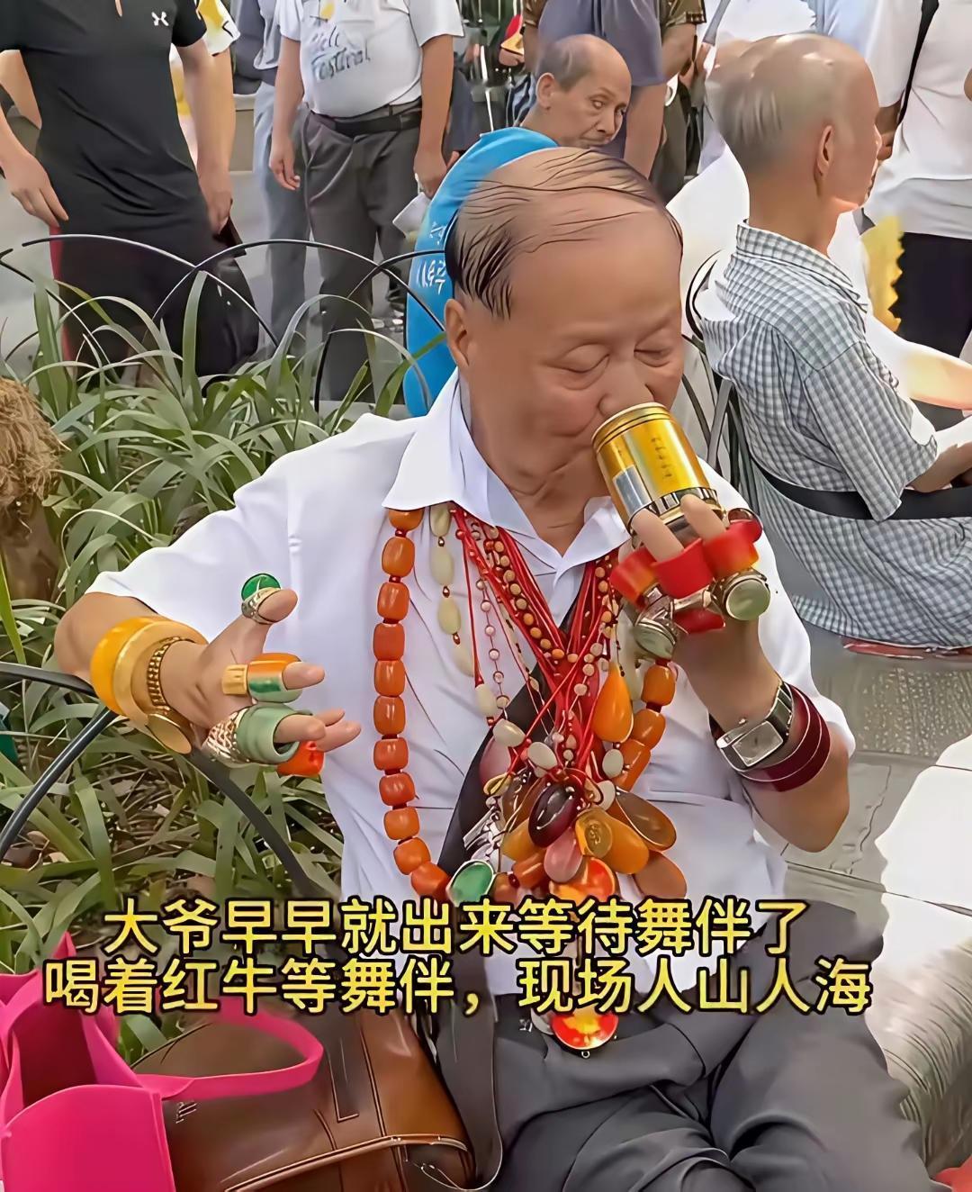 这大爷跳个广场舞，还不忘记炫富，你看大爷脖子上挂的，个个手指上戴着，喝着红牛，在