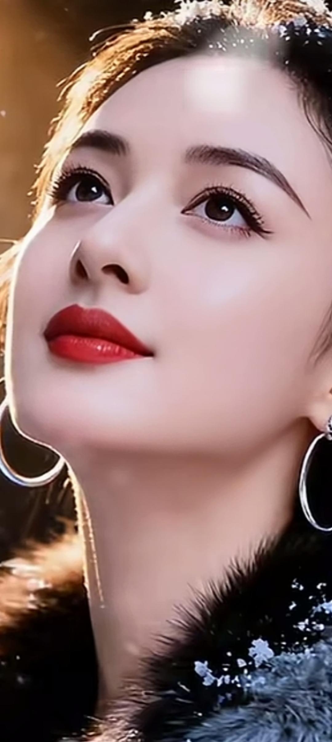 冬日暖阳下的红唇美人，闪耀的耳环和毛绒外套，尽显优雅与魅力。