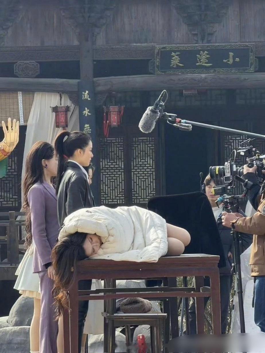 韩安冉直接躺在拍摄桌上就睡，其他人还在拍摄。