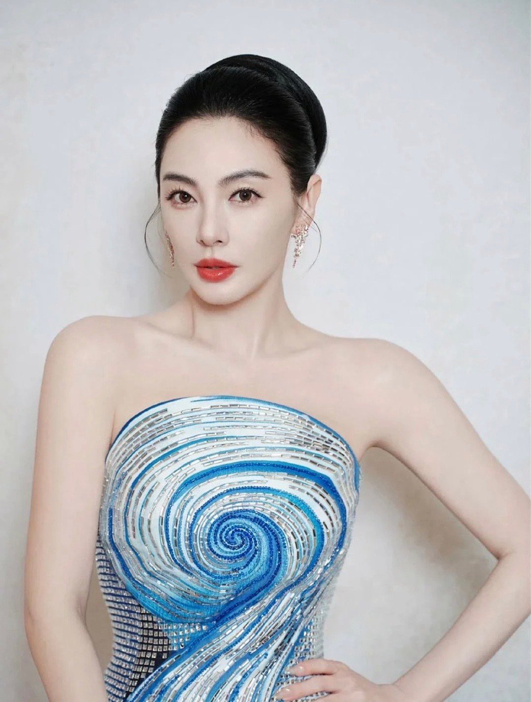 张雨绮身穿一袭蓝白海洋漩涡抹胸礼服，亮片钻饰流光溢彩，抹胸设计衬出肩颈线条，肤白