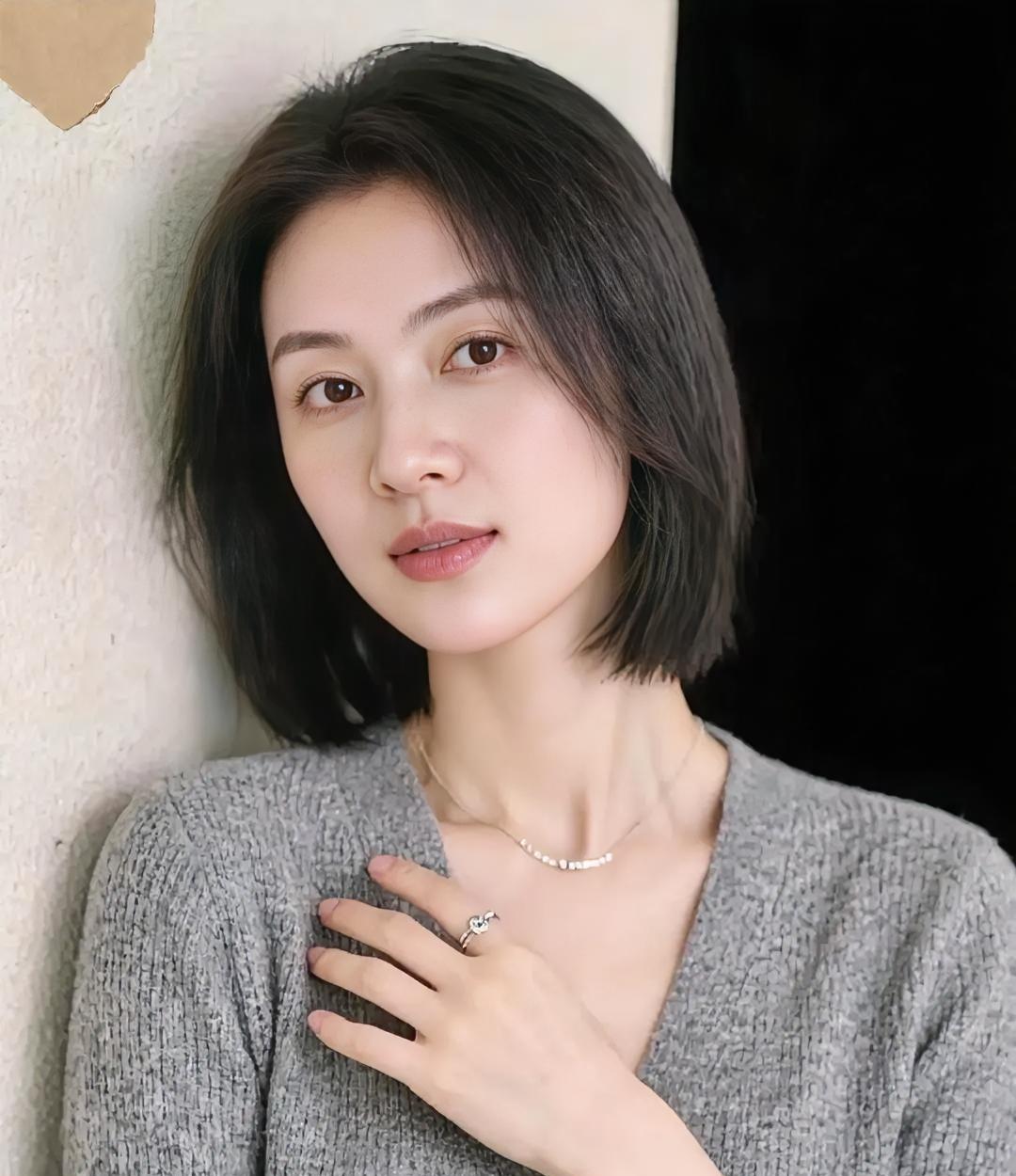 短发挨着墙的暖灰毛衣织进软时光手轻放，像按着心跳细链在颈间发亮目