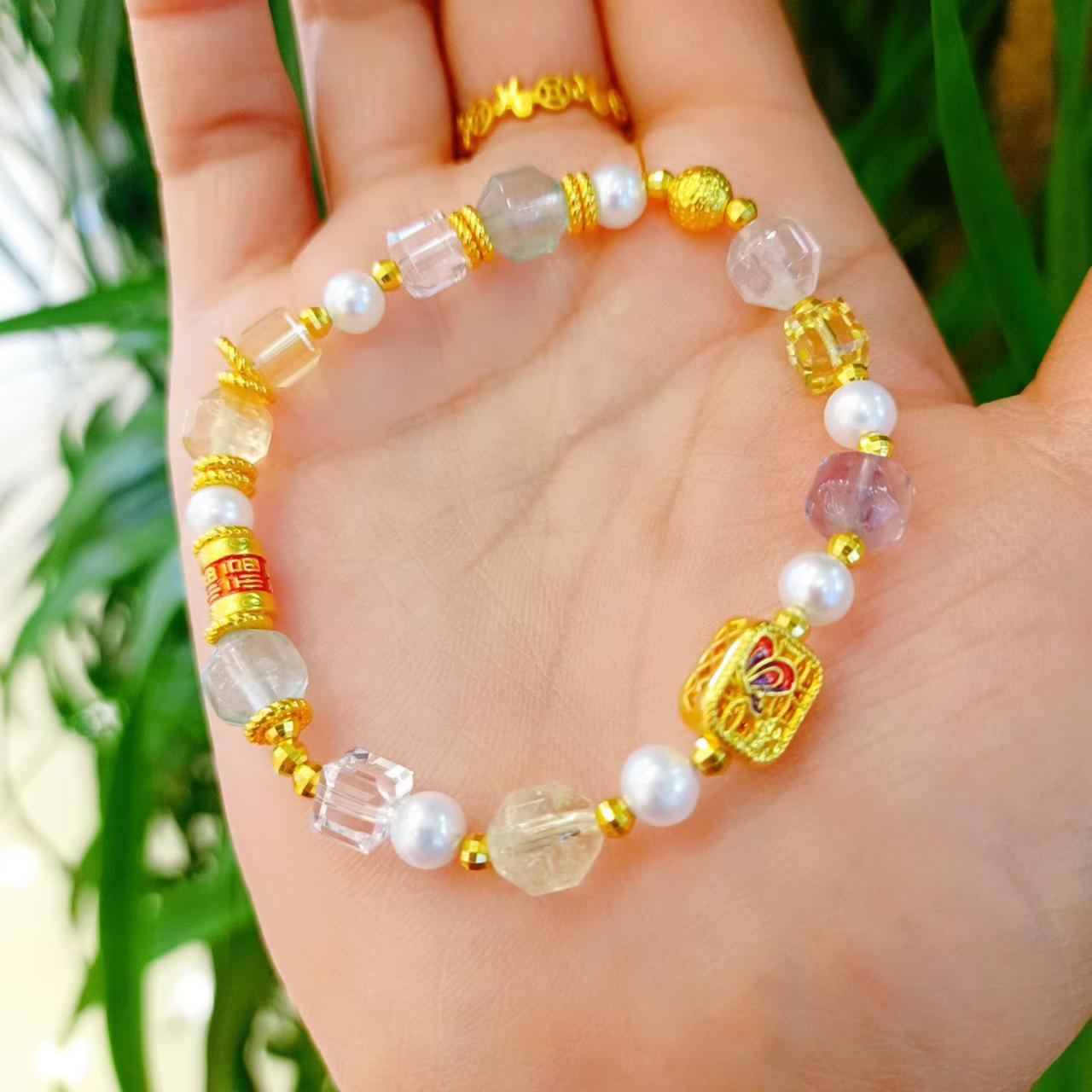 手上的手链真漂亮，有珍珠和彩色珠子。