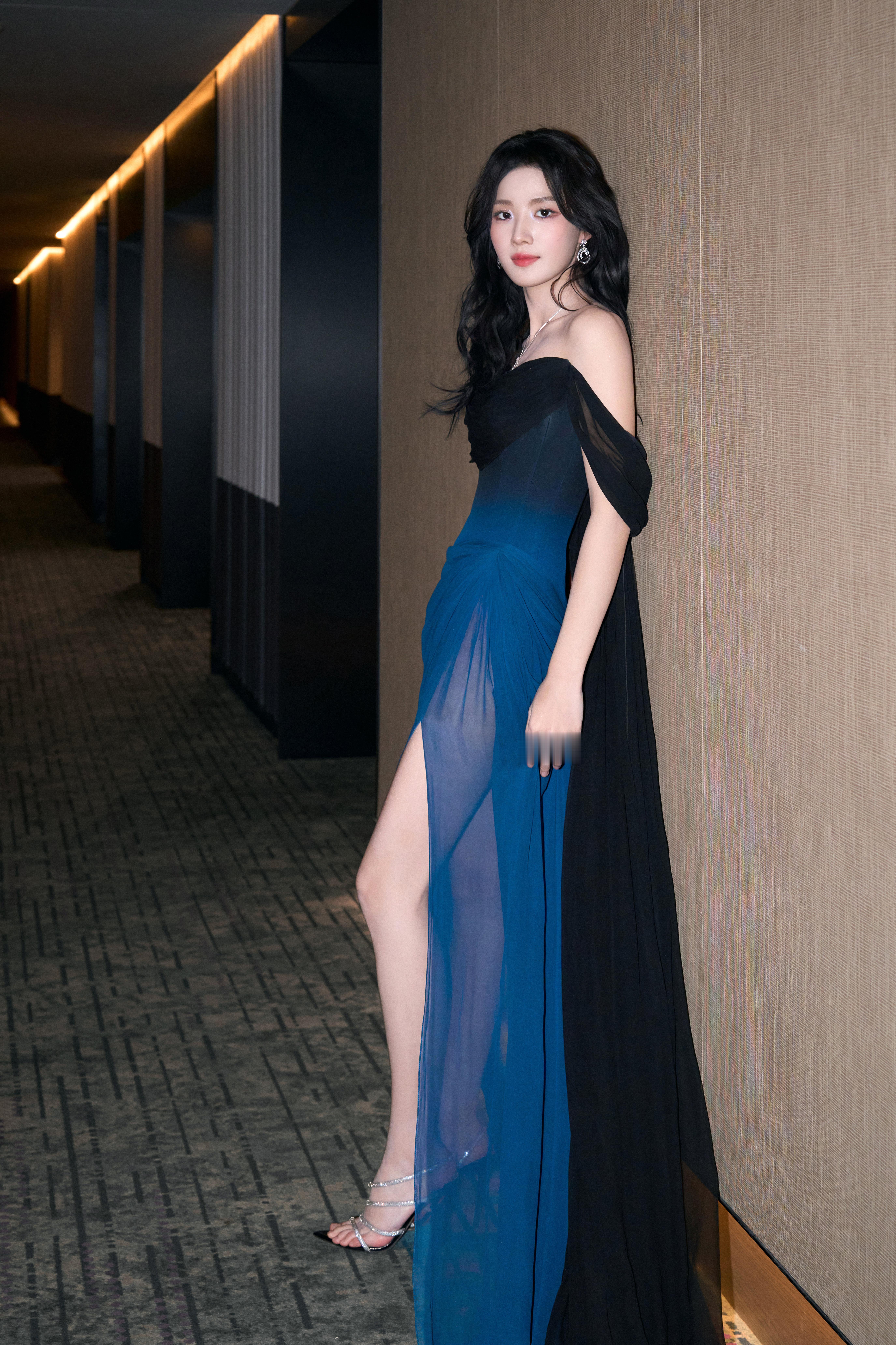 卢昱晓黑蓝纱裙如夜色翻涌，高开叉下的长腿在雾色里若隐若现。