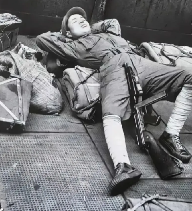 1949年，上海，镜头一名即将撤往台湾的士兵躺在地上休息，看起来很疲惫，也很失落