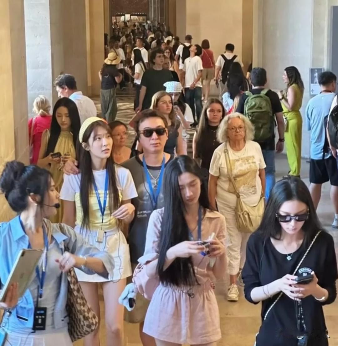 王思聪和多名年轻女生结伴参观罗浮宫，一行人都佩戴了讲解器挂绳。王思聪手臂搭在旁边