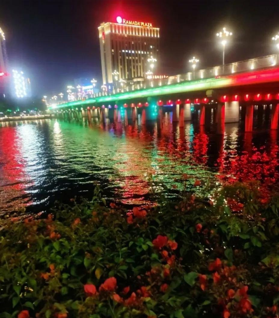 #拍一张你的城市美景#《夜游观桥》华灯映水卧长桥，彩练流光夜色娇。花草香随