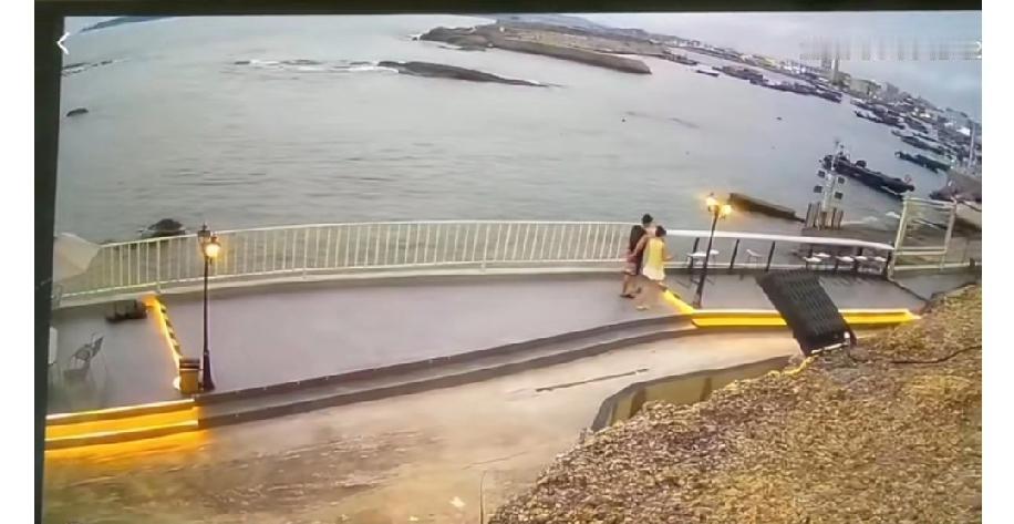 一对情侣在海边散步，当时已近黄昏，观光步道上的路灯已经点亮了，明明已经过了这个路