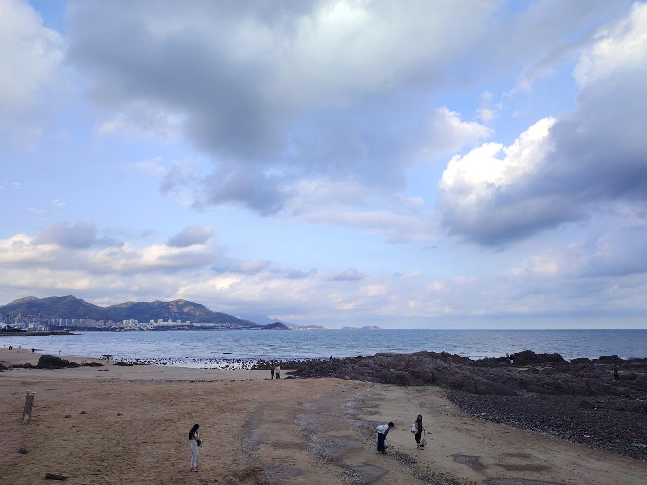 青岛雕塑园的秋，是风云与山海的狂想曲。云层如巨浪翻滚，金光穿透云隙洒向海面，尽显
