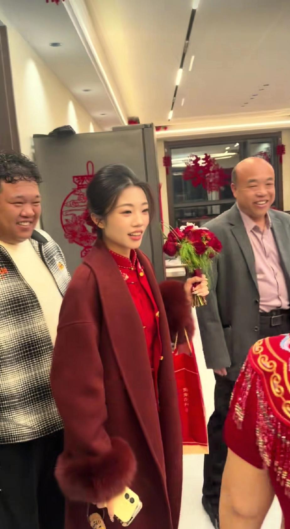 解清帅的大妹长得十分漂亮，回门时身着喜庆的红色旗袍，外面套着一件羊绒大衣，手捧鲜