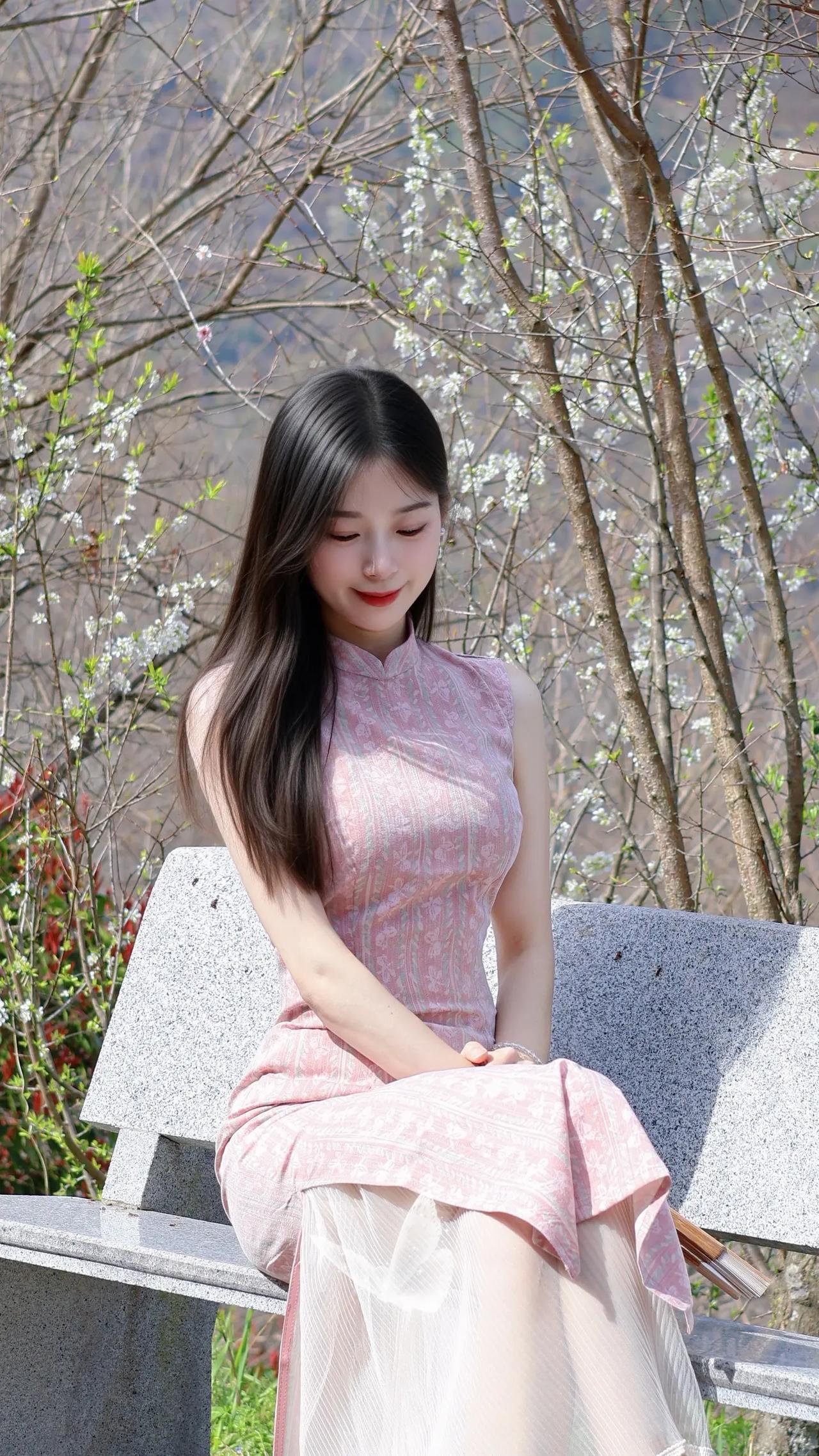 春日暖阳下，粉裙少女静坐花丛中，温柔如水。