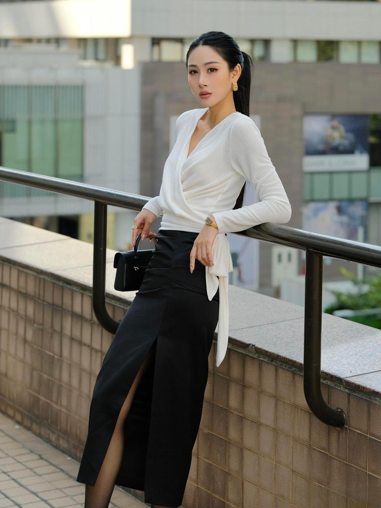 这套穿搭是经典黑白配的轻熟优雅风，简约中透着高级质感。白色交叉绑带V领上衣设计感