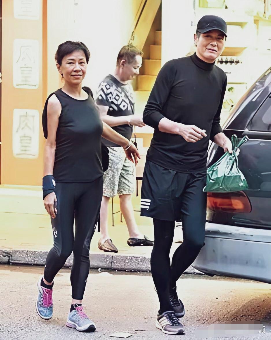 周润发和妻子陈荟莲走在香港街头，一身运动服，提着购物袋子，亿万身家，日子过得简单
