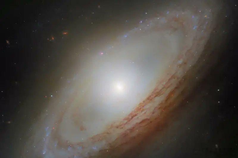 乍一看，NGC4698看起来像一个规矩的螺旋星系：一个发光的中心、尘埃通道，
