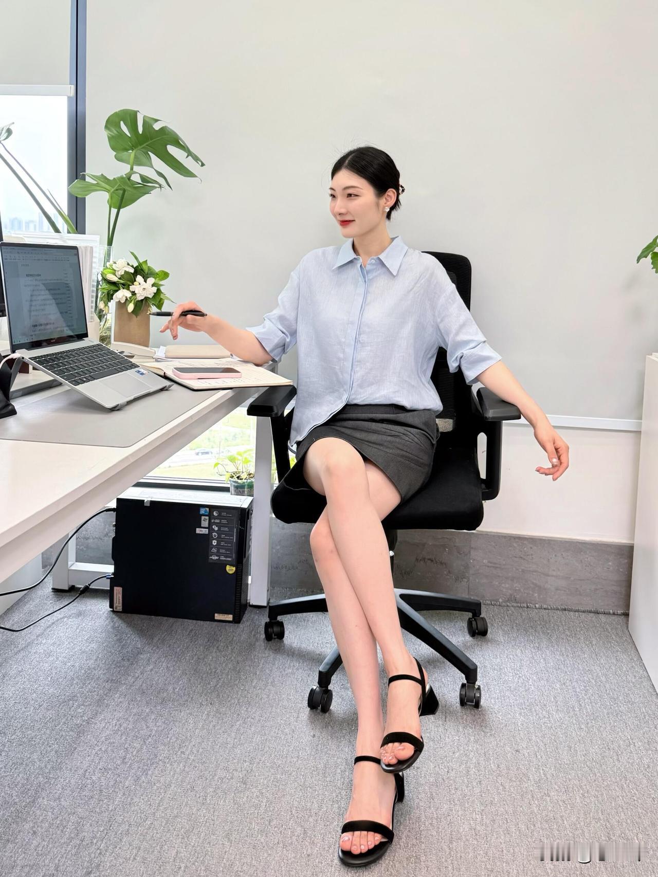办公室里，一个穿裙子的女士坐着。