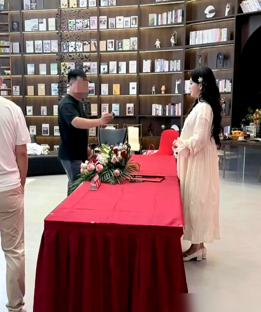 金莎小腹隆起，孙丞潇在台阶上全程用手护着她后腰，动作像捧着个易碎品。媒体见面会，宽松长裙，圆润身形。