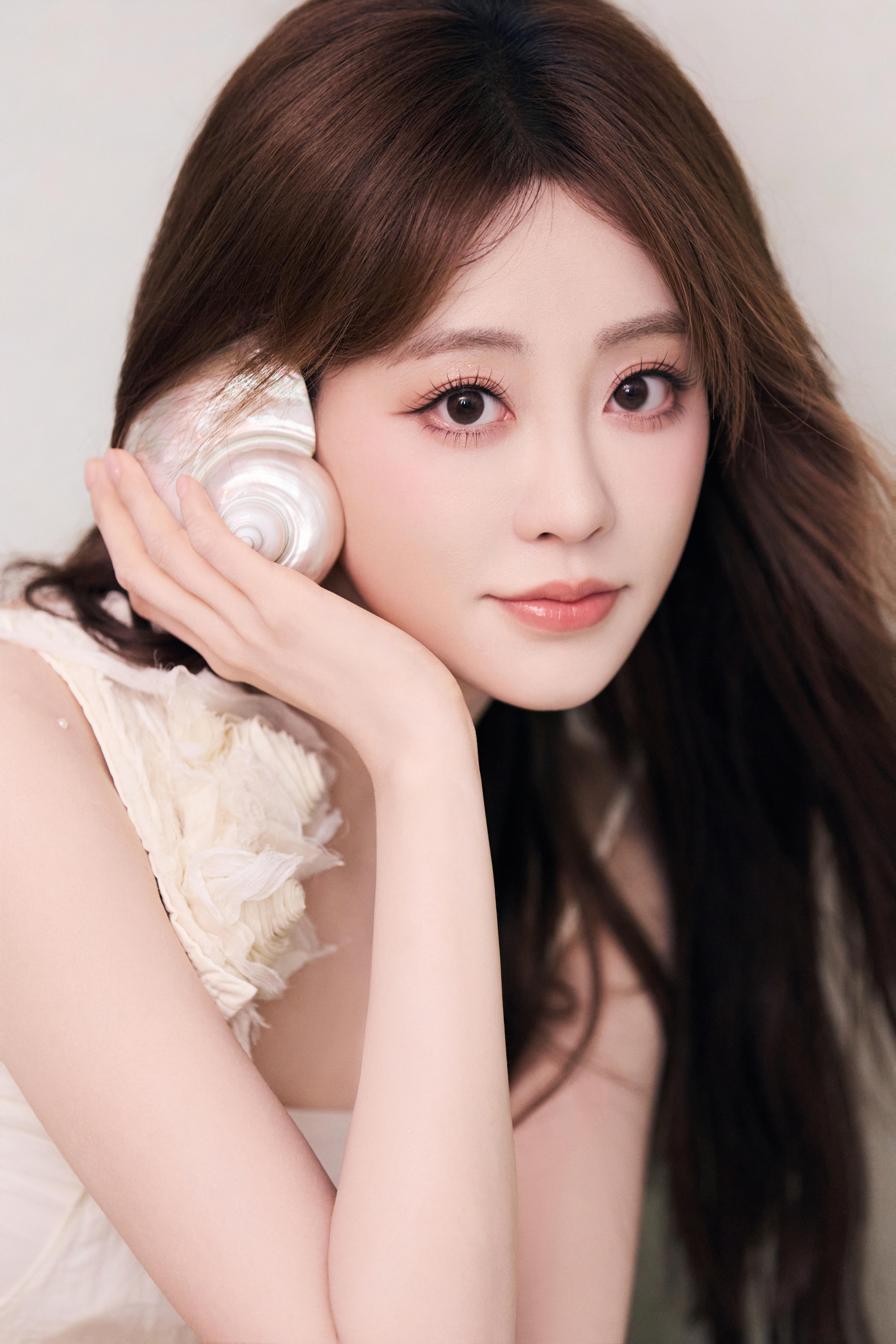 祝绪丹一袭米白长裙，缀花饰肩，似林间精灵坠入梦境。