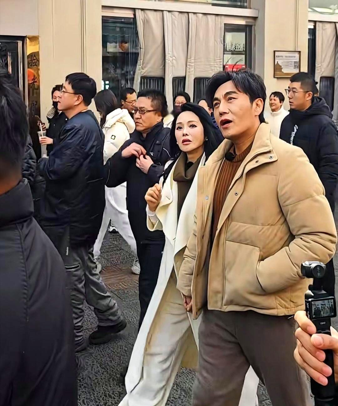 沈阳中街，57岁伊能静的大衣吊牌，晃了一路。旁边秦昊瘦了一大圈，全程十指紧