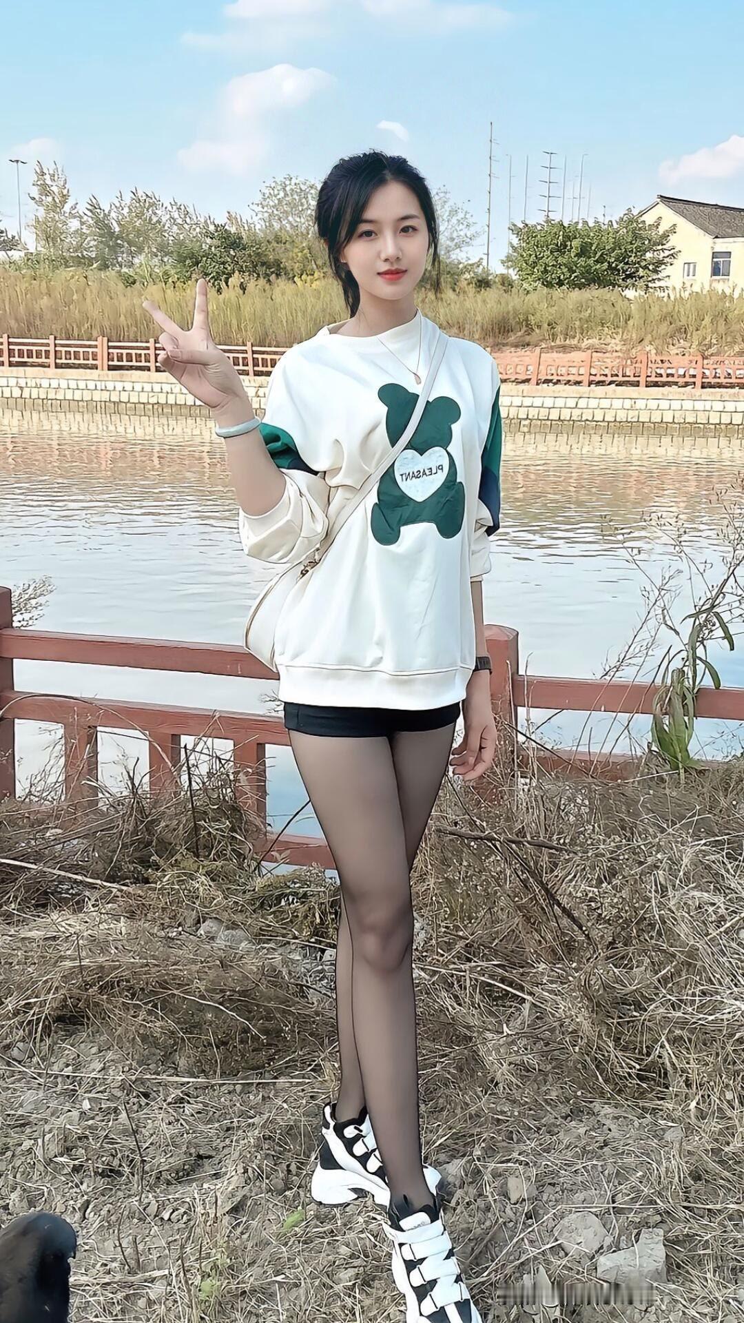 青春洋溢的少女在湖边比出V字手势，阳光明媚，心情大好！🌞👍🏻