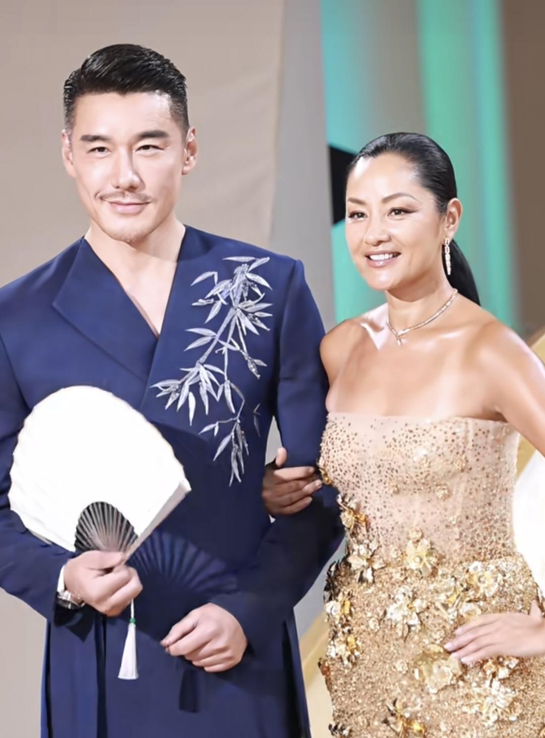 胡兵瞿颖一起参加活动，瞿颖穿金色绣花半透明抹胸长裙，胡兵穿蓝色绣花复古长衫，