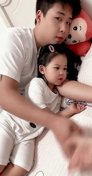 父女俩正在享受着温馨的一刻，妈妈也想过来分享一下，便把手伸过去，想摸摸闺女的小手