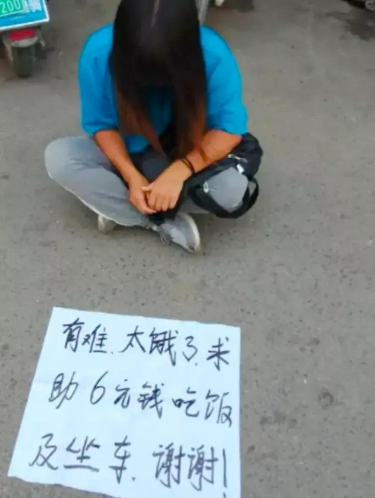 刚出地铁口就碰见这揪心的一幕，一个小女孩坐在地上，面前的牌子上写着:有难，太饿了