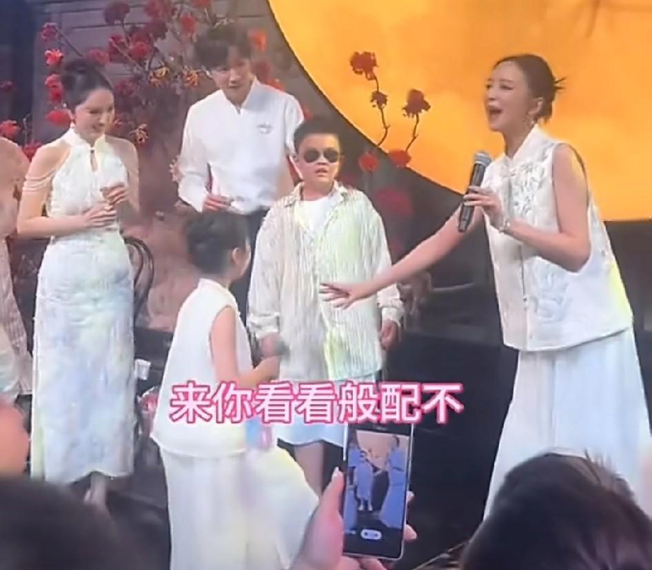 董璇和张维伊的婚礼上，佟丽娅拉着小酒窝站在儿子朵朵身边问台下宾客：“般配不？”宾