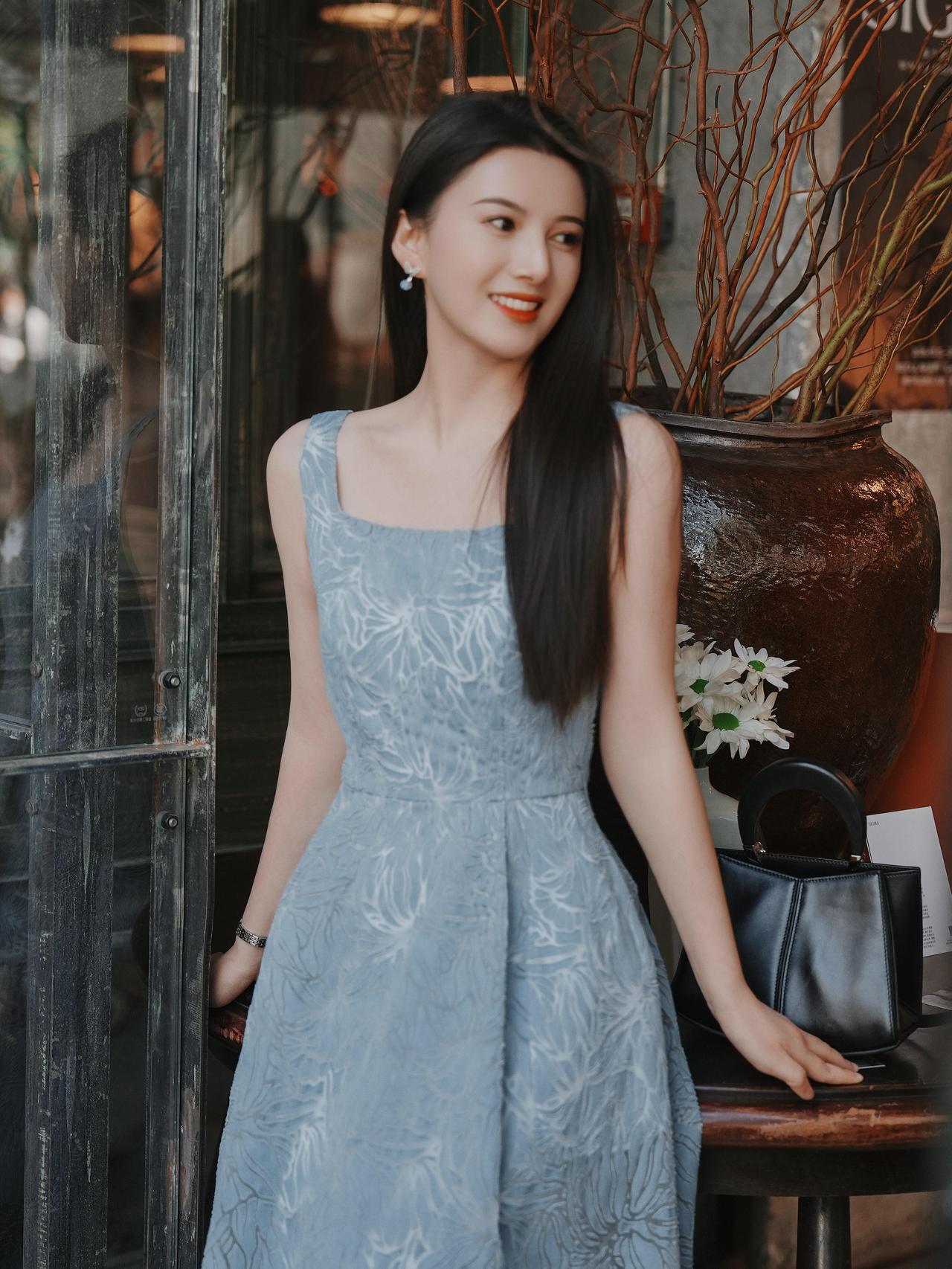 优雅蓝裙少女，微笑倚靠窗边，复古咖啡馆氛围