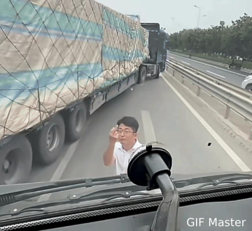 公路惊险一幕！男子因行车纠纷拦停大货车，并不断竖中指挑衅货车司机。可能是别车，可