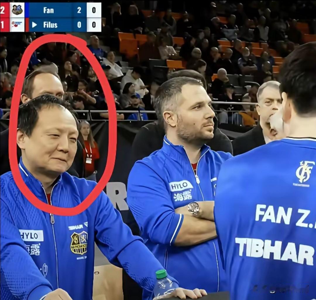 樊振东的教练王志，嘴角都快压不住了。不能笑，憋住绝对不能笑。给樊振东当教