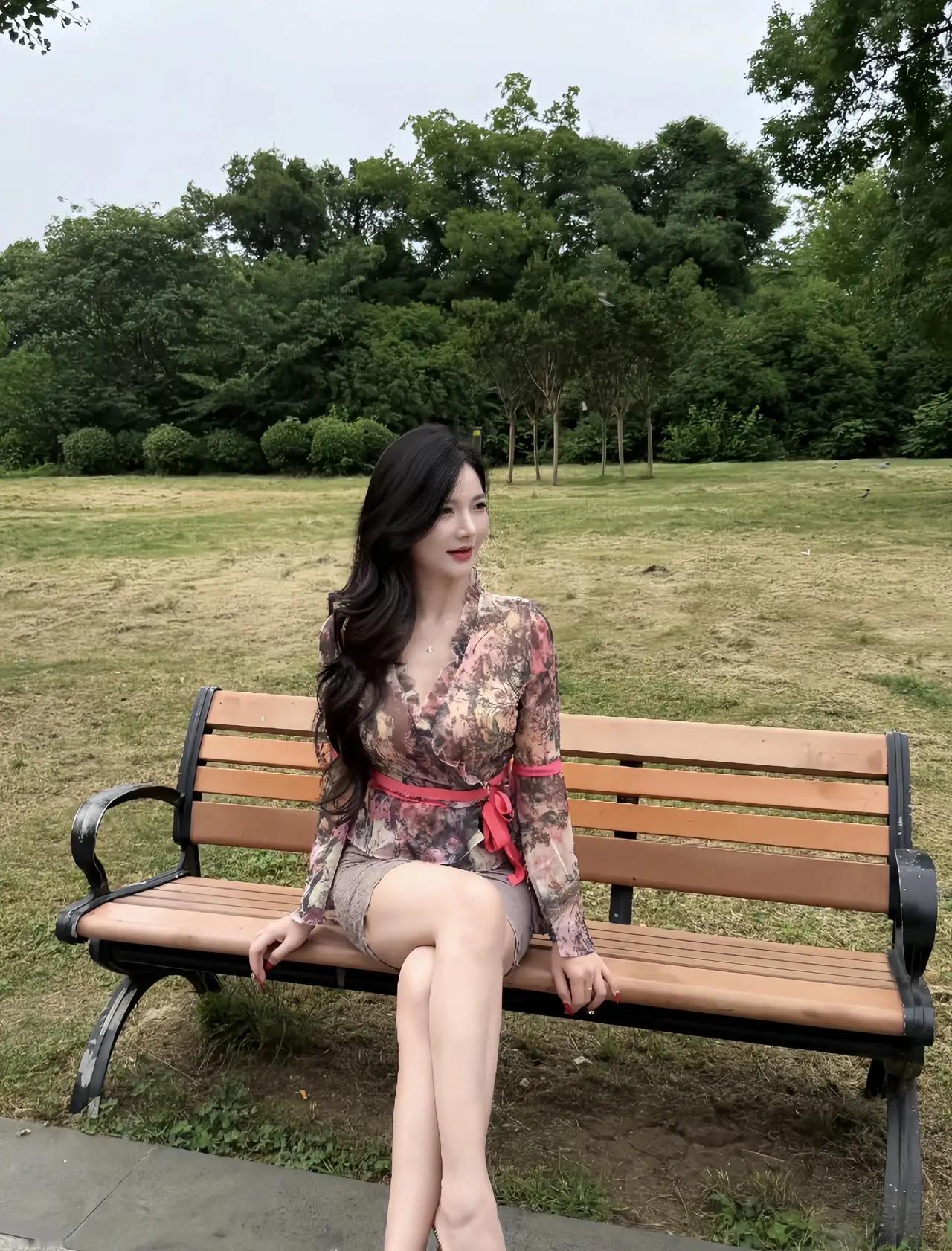 美女坐在公园的长椅上，优雅漂亮。