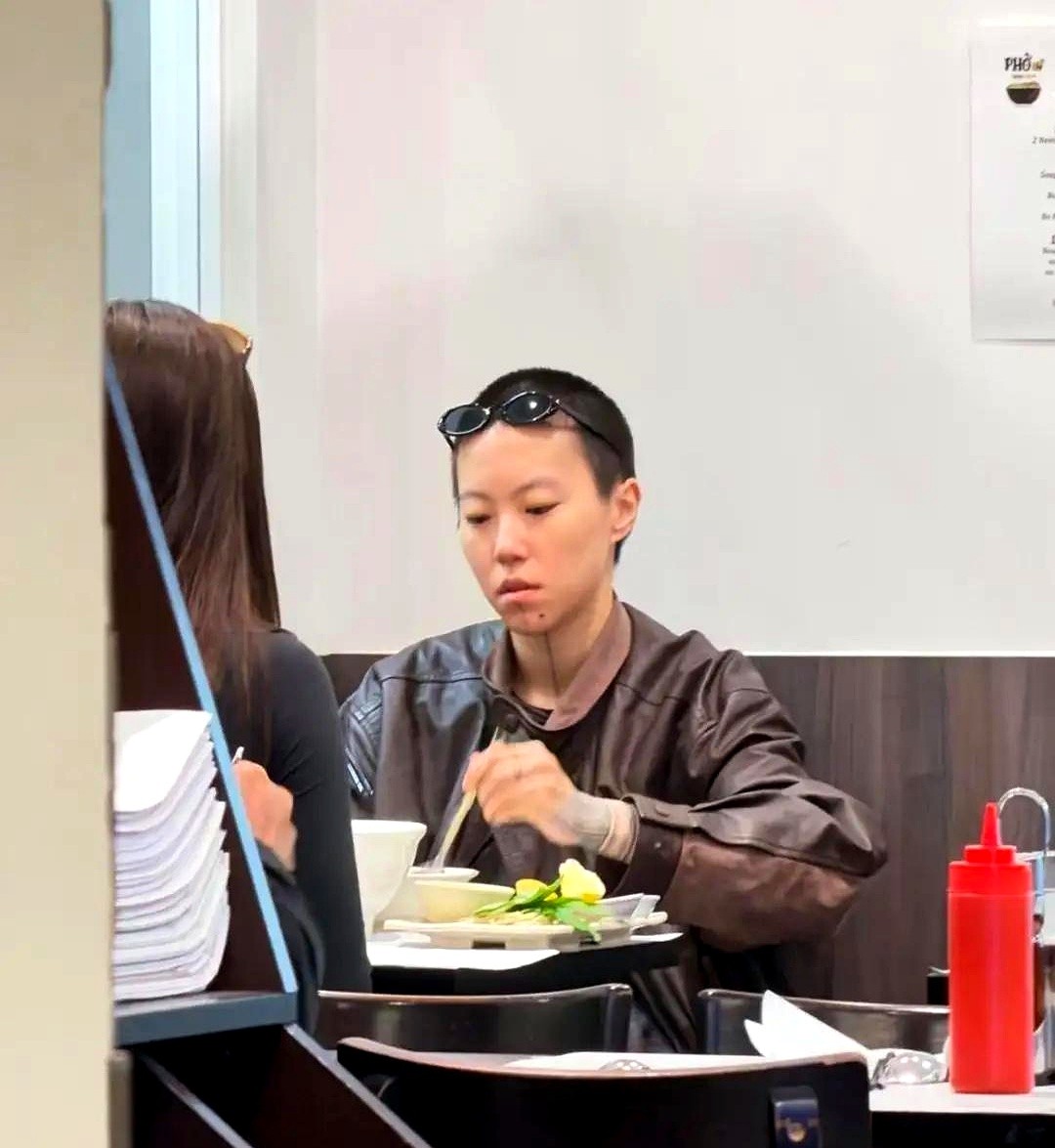 巴黎街头一家拥挤的越南粉店里，一个顶着寸头、下巴带着纹身的女孩正低头猛嗦河粉。路人的手机镜头都快怼脸
