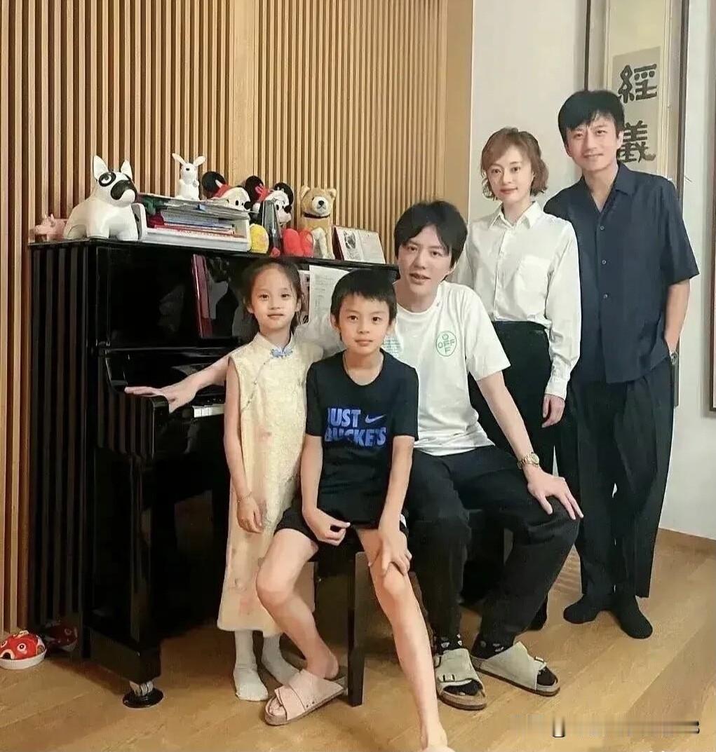 早些年孙俪、邓超还有孩子们的一张合影，他们站在钢琴旁，应该是孩子上完了钢琴课，那