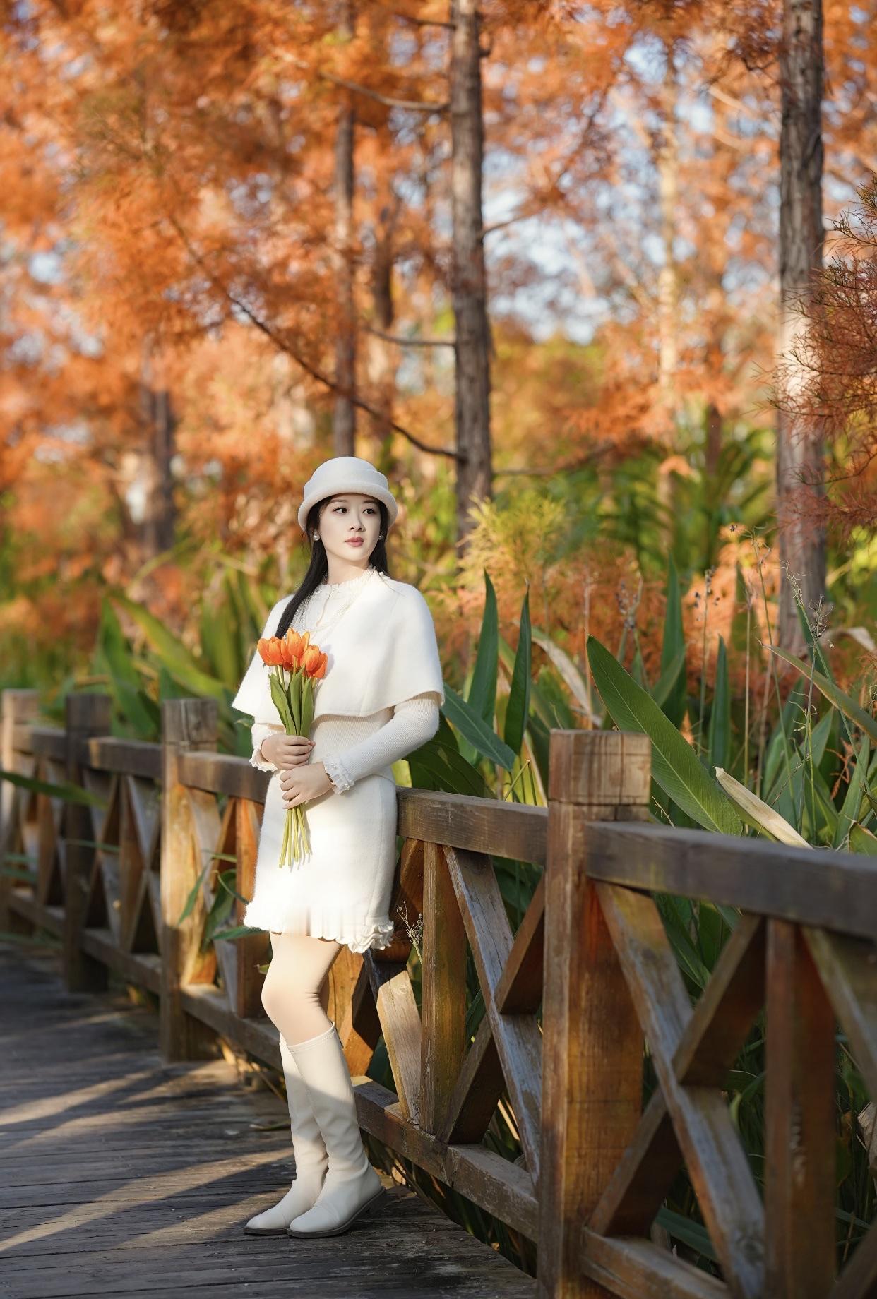 治愈系少女写真怎么拍秋日森林中的优雅少女，手持橙色郁金香，漫步在木桥上。