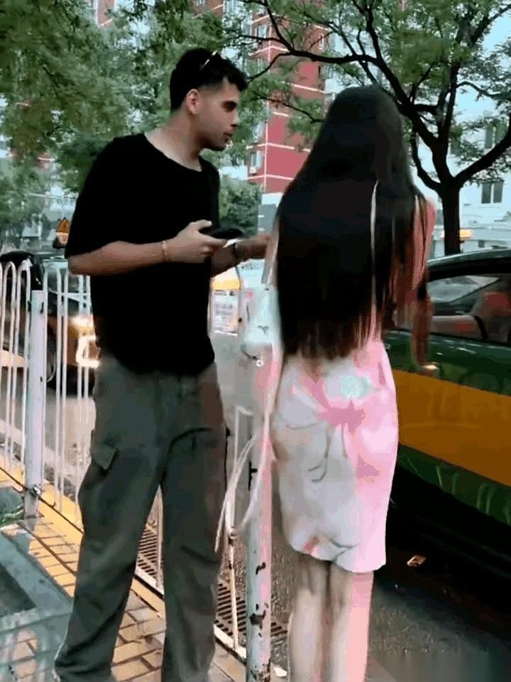 手机屏幕都快怼到人家姑娘鼻子底下了。一个印度青年亦步亦趋地跟在后面，哪怕前面那