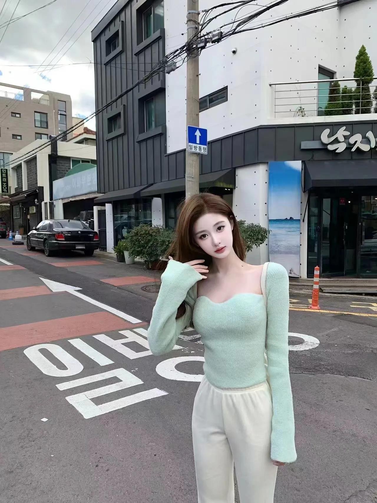 绿衣美人立街边，春风吹拂心自闲。