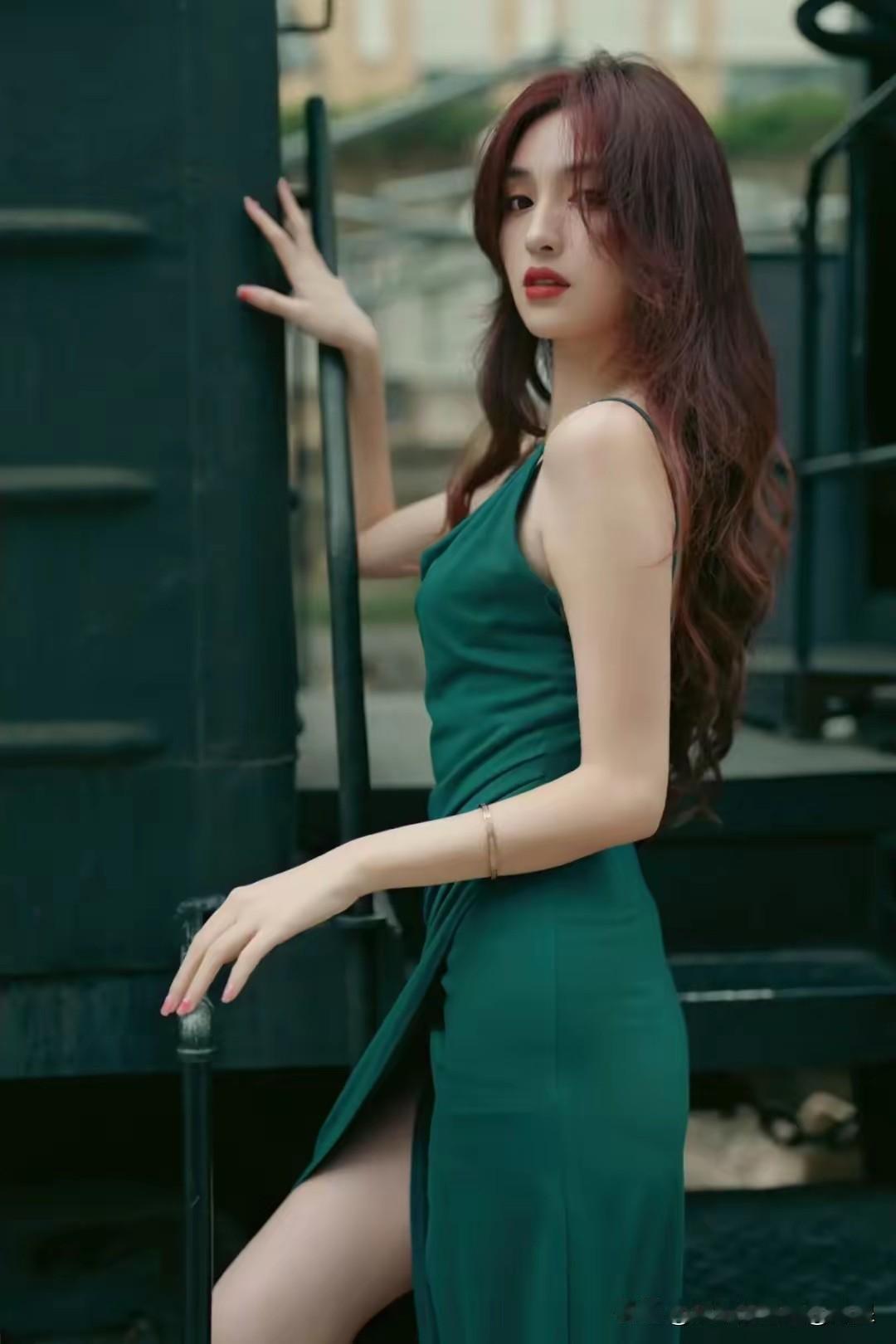 绿皮火车为何还是如此受欢迎?优雅绿裙少女，复古火车旁，红发飘逸，复古风情。