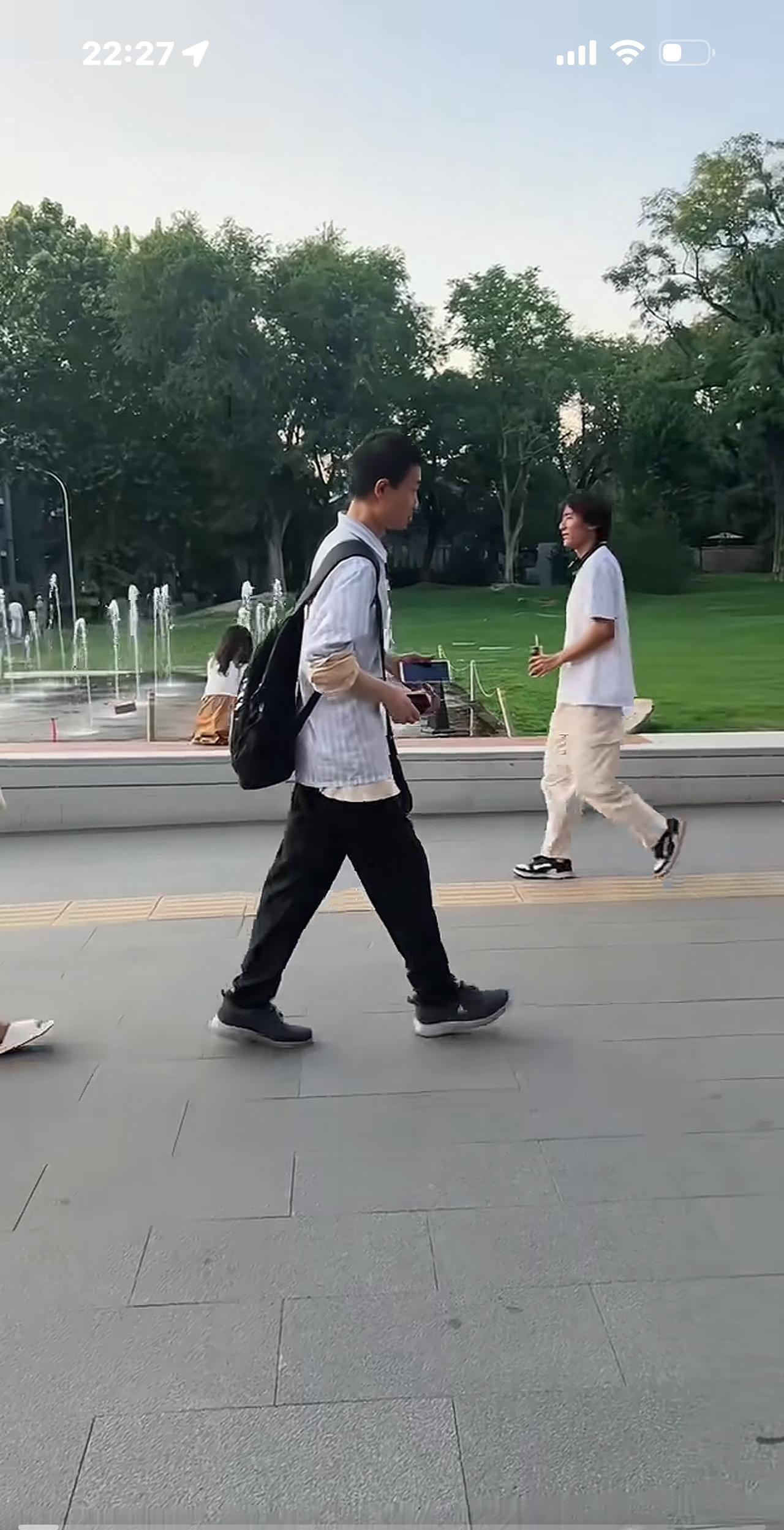 没想到，韦神走路也看手机，跟我们一样，他还拿了两个手机，在北大校园匆匆走着。今天