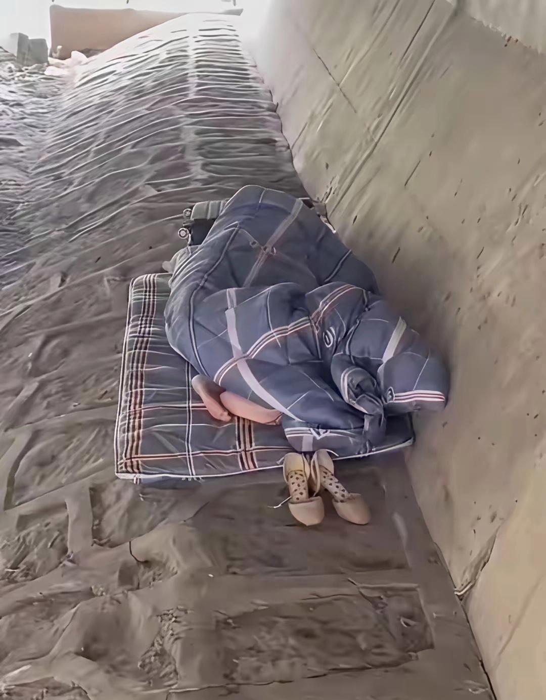 看鞋子应该是个年轻的女子，为啥不找个工作非地睡在桥洞下面啊？