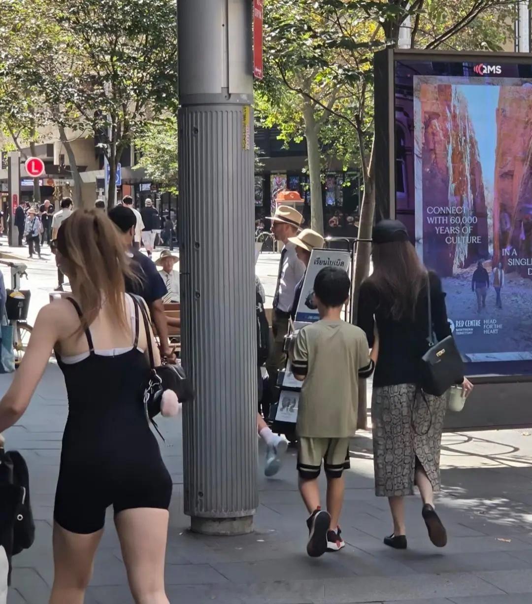 侯佩岑和老公带两个儿子在身悉尼逛街，她穿着开叉印花短裙，身材纤瘦匀称，长发披肩好